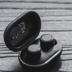 Sepasang earbud nirkabel di dalam kotak pengisi daya