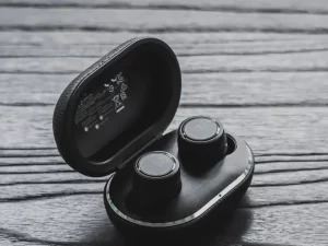 Sepasang earbud nirkabel di dalam kotak pengisi daya