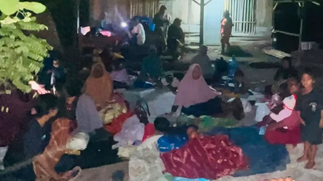 Warga terdampak gempa duduk beralaskan tikar dan terpal di luar rumah pada malam hari