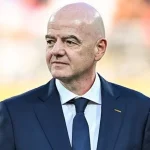Presiden FIFA Gianni Infantino mengenakan setelan jas berdiri di tepi lapangan