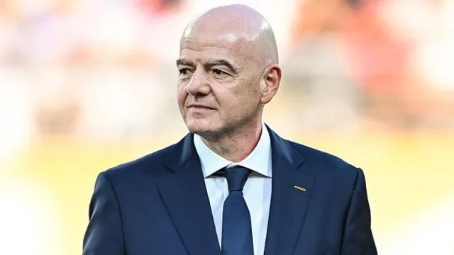 Presiden FIFA Gianni Infantino mengenakan setelan jas berdiri di tepi lapangan