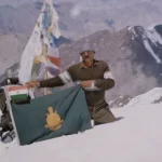Dorje Morup mengenakan pakaian pelindung di puncak bersalju saat mendaki gunung