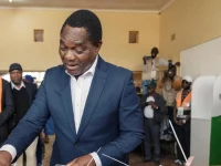 Presiden Zambia Hakainde Hichilema memasukkan surat suara ke kotak suara