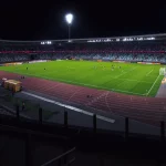Stadion sepak bola terang benderang saat malam hari