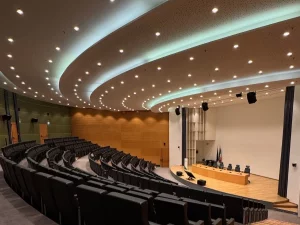 Ruang auditorium modern dengan deretan kursi menghadap panggung