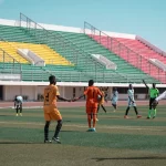 Para pemain bertahan berjaga di lapangan pada sebuah pertandingan sepak bola