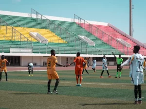 Para pemain bertahan berjaga di lapangan pada sebuah pertandingan sepak bola