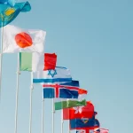 Bendera berbagai negara berkibar di bawah langit biru