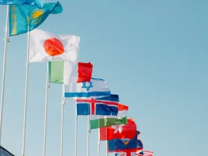Bendera berbagai negara berkibar di bawah langit biru