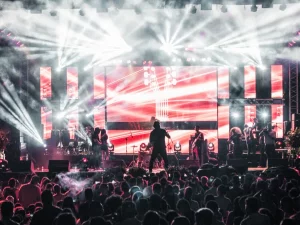 Penampil di atas panggung konser dengan tata cahaya terang
