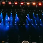 Penonton dan panggung konser dengan efek cahaya warna-warni