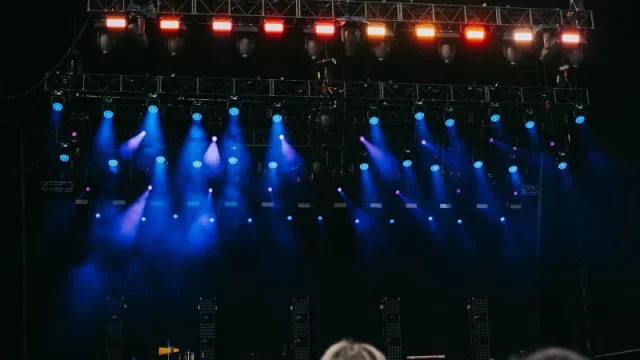 Penonton dan panggung konser dengan efek cahaya warna-warni