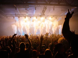 Penonton menikmati konser dengan efek cahaya dan asap