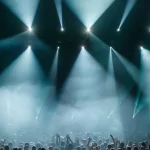 Kerumunan penonton menikmati konser dengan tata cahaya