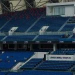 Deretan kursi tunggal di tribun stadion