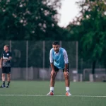 Dua pemain sepak bola berlatih di lapangan hijau