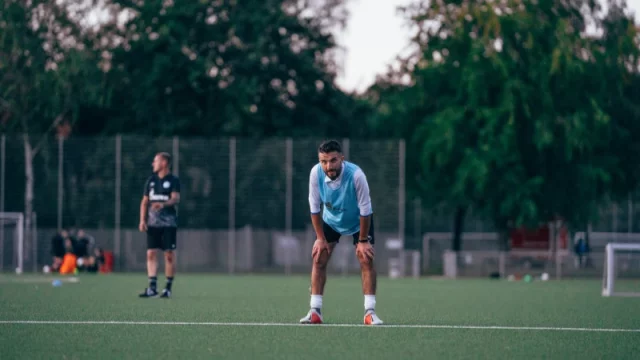 Dua pemain sepak bola berlatih di lapangan hijau