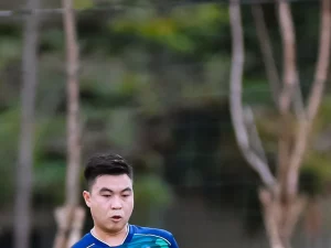 Seorang pesepak bola berkostum biru di lapangan