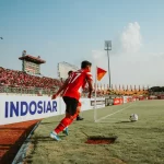 Pemain menggiring bola dalam laga di Indonesia