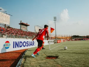Pemain menggiring bola dalam laga di Indonesia