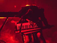 Isyana Sarasvati tampil dramatis di atas panggung dengan pencahayaan merah sambil memainkan keytar