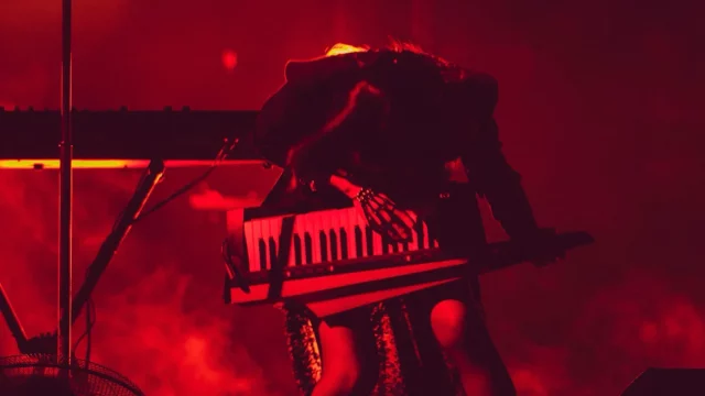 Isyana Sarasvati tampil dramatis di atas panggung dengan pencahayaan merah sambil memainkan keytar