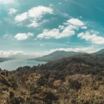 Danau dikelilingi perbukitan hijau