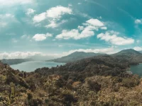 Danau dikelilingi perbukitan hijau