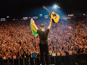 Anggota Mumford & Sons tampil di panggung festival musik menghadap kerumunan penonton