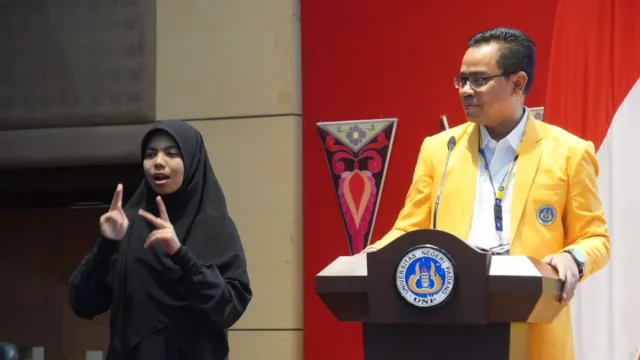 Juru bahasa isyarat menerjemahkan sambutan untuk mahasiswa baru tuli dalam PKKMB Universitas Negeri Padang 2026