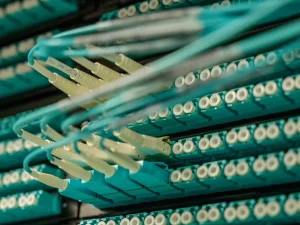 Untaian kabel serat optik terhubung ke rak perangkat jaringan