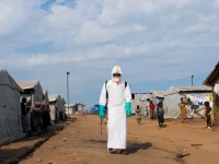 Petugas kesehatan berpakaian alat pelindung diri lengkap bersiap mendisinfeksi area pemakaman korban Ebola di kamp pengungsi Kigonze, Bunia, Republik Demokratik Kongo.