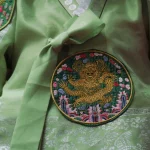 Detail kain hanbok hijau dengan bordir lingkaran bermotif naga.