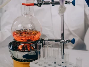 Labu kaca berisi cairan yang dipanaskan di laboratorium kimia