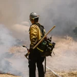 Petugas pemadam kebakaran bekerja di tengah asap dan api kebakaran hutan
