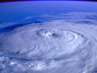 Pusaran hurikan dengan mata badai terlihat jelas dari orbit di atas lautan