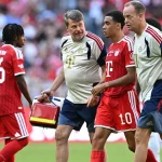 Jamal Musiala dipapah keluar lapangan oleh tim medis Bayern Munich.