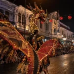 Ilustrasi seorang penampil mengenakan kostum karnaval bersayap lebar berhias bulu dan untaian lampu kecil dengan hiasan kepala menyerupai kepala naga, berarak di jalan kota berbangunan kolonial pada malam hari