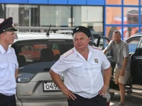 Petugas Cossack berjaga di antrean kendaraan pada sebuah stasiun pengisian bensin di Anapa, Rusia, saat kelangkaan bahan bakar.