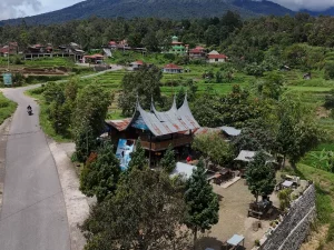 Ilustrasi kampung Minangkabau dengan rumah gadang dan petak sawah di lereng perbukitan.
