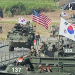 Kendaraan lapis baja dan bendera Korea Selatan serta Amerika Serikat