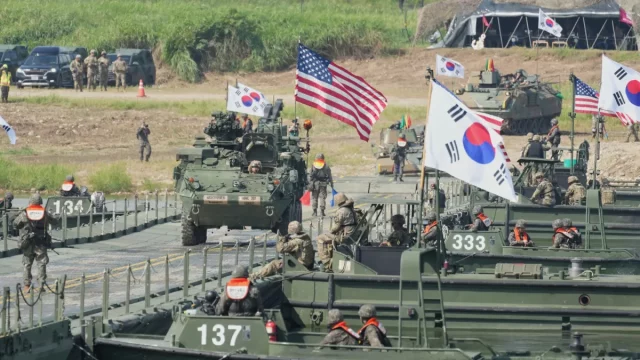 Kendaraan lapis baja dan bendera Korea Selatan serta Amerika Serikat