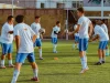 Ilustrasi sekelompok pemain sepak bola usia muda berlatih menggiring dan mengoper bola di lapangan rumput