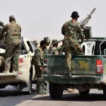 Tentara Suriah era Bashar al-Assad berdiri di atas kendaraan bak terbuka di Deir Az Zour