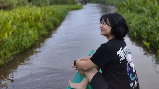 Leony duduk di atas perahu saat menyusuri sungai di Kalimantan.