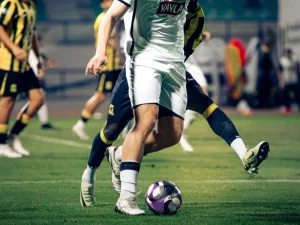 Pesepak bola berebut bola dalam sebuah pertandingan