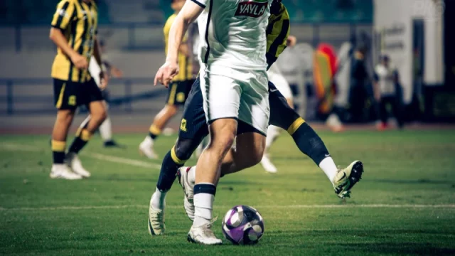 Pesepak bola berebut bola dalam sebuah pertandingan