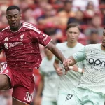 Pemain Liverpool berseragam merah berduel merebut bola dengan pemain Monaco berseragam hijau muda