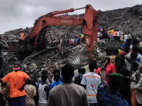 Warga dan tim penyelamat menggunakan ekskavator mencari jenazah korban longsor TPA Dar-es-Salam, Conakry
