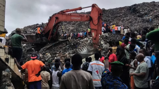 Warga dan tim penyelamat menggunakan ekskavator mencari jenazah korban longsor TPA Dar-es-Salam, Conakry